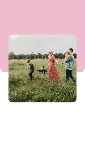 liebevoll aufwachsen – Eine Familie mit zwei Kindern und Baby spaziert fröhlich durch eine weite, grüne Wiese. Alle wirken verbunden, frei und glücklich – Symbol für eine sichere Bindung und ein erfülltes Familienleben.